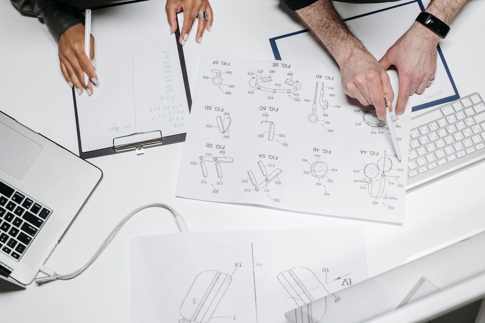 Two professionals collaborate on product design with technical diagrams and notes.